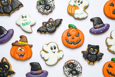 Tasty Halloween cookies on white table, flat lay