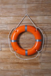 Photo of Orange lifebuoy on wooden background. Rescue equipment