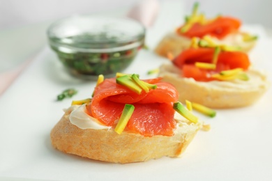 Photo of Sandwiches with fresh sliced salmon fillet and avocado on table, closeup