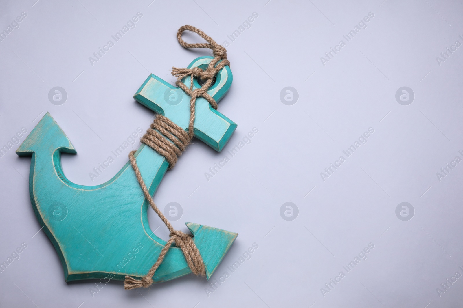 Photo of Wooden anchor figure on light background, top view. Space for text