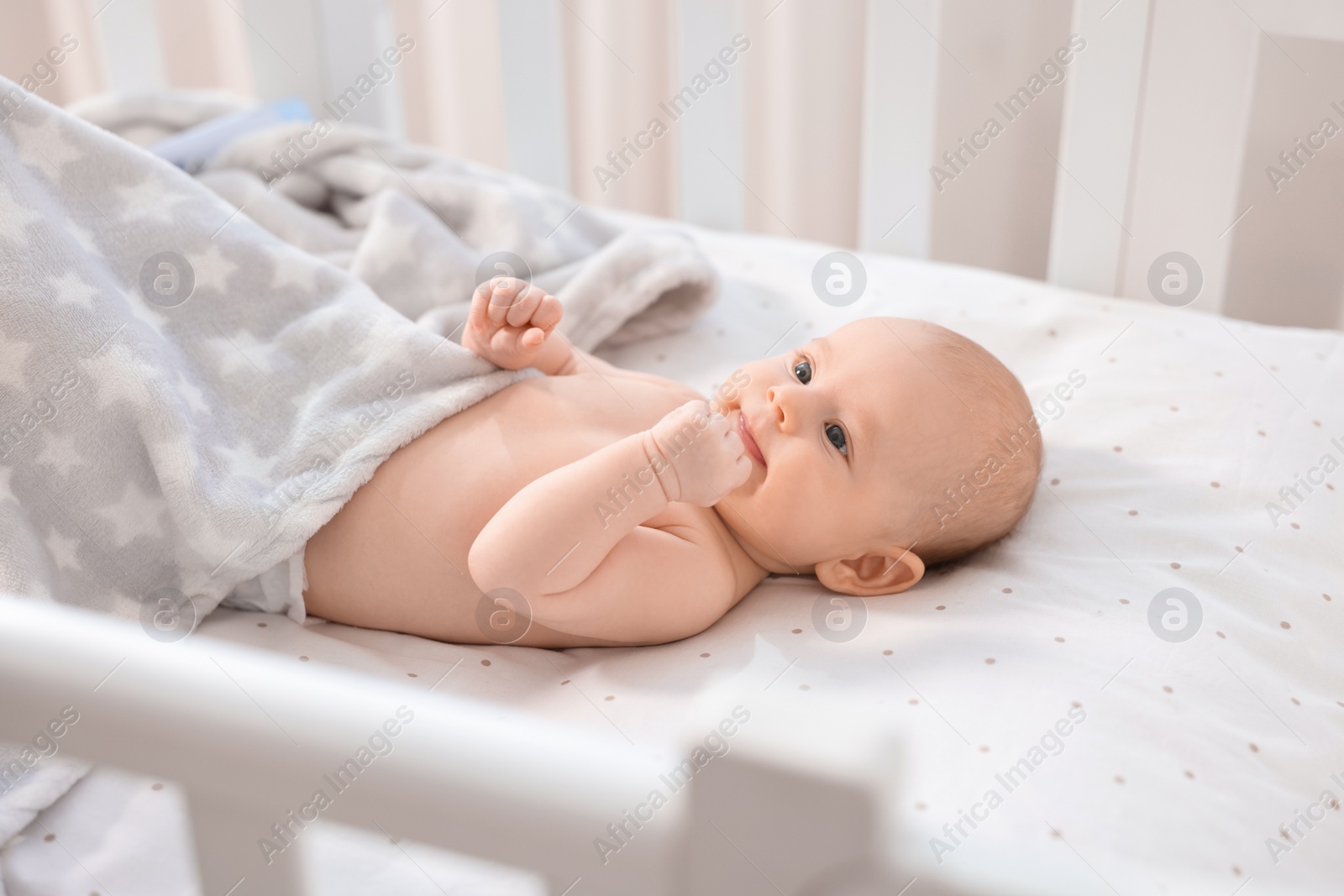 Photo of Cute little baby lying in crib at home