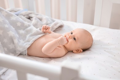 Cute little baby lying in crib at home