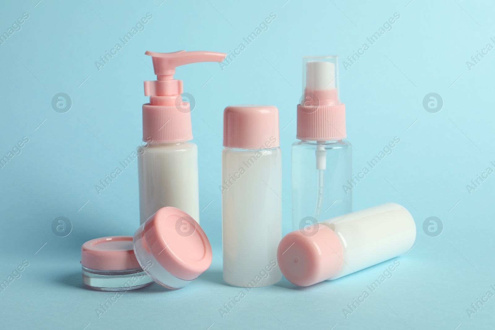 Photo of Cosmetic travel kit on light blue background. Bath accessories