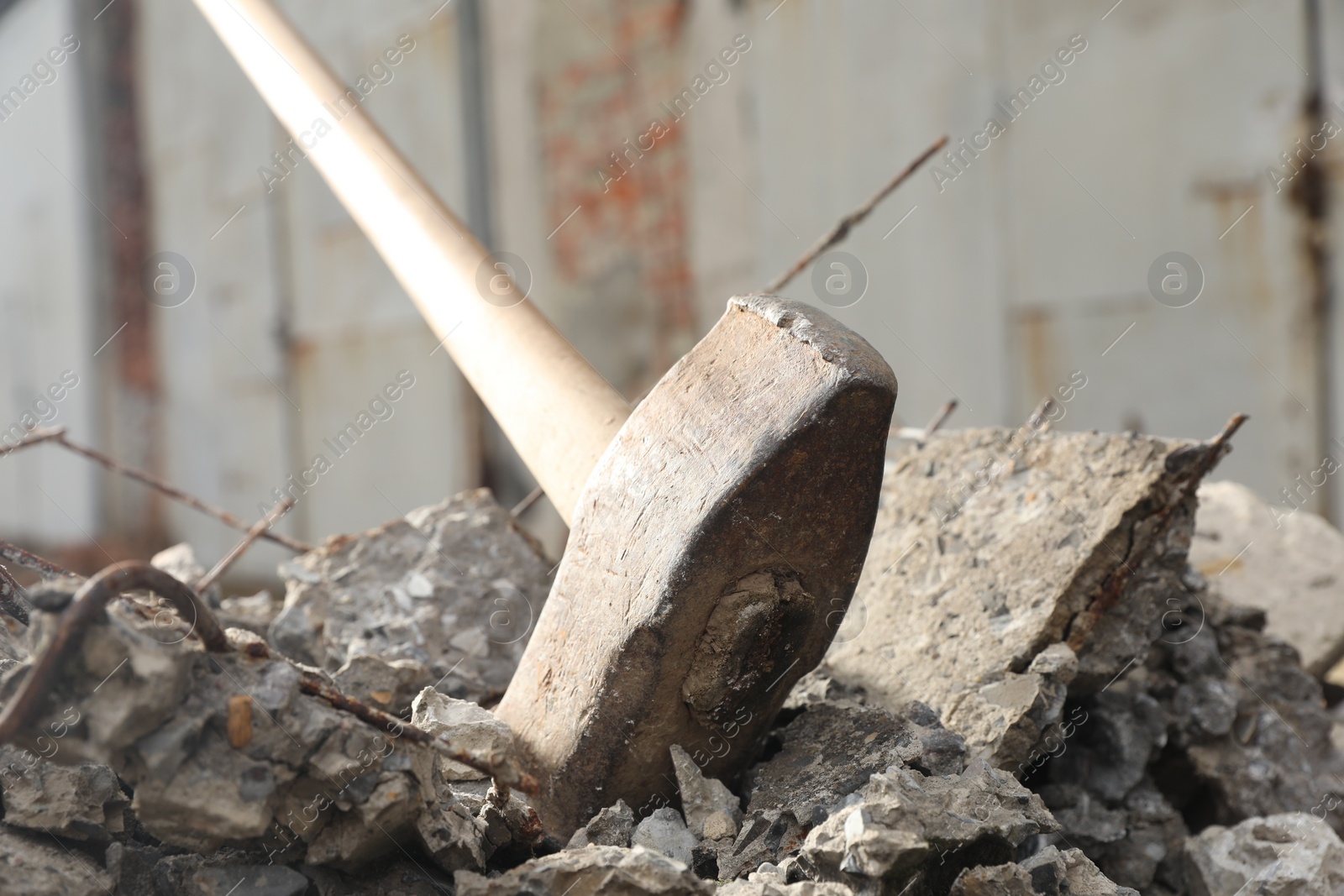 Photo of Sledgehammer on pile of broken stones outdoors, closeup