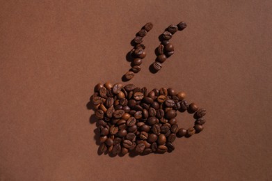 Photo of Cup of hot drink, composition made with coffee beans on brown background, flat lay