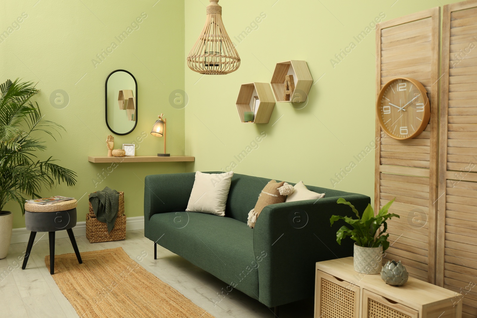 Photo of Living room with comfortable green sofa. Interior design