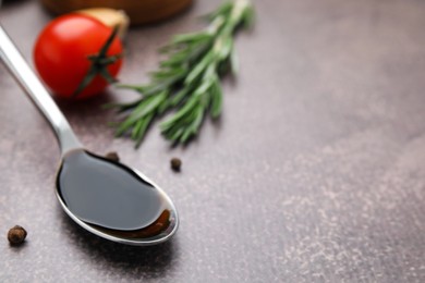 Organic balsamic vinegar and cooking ingredients on grey table, closeup. Space for text