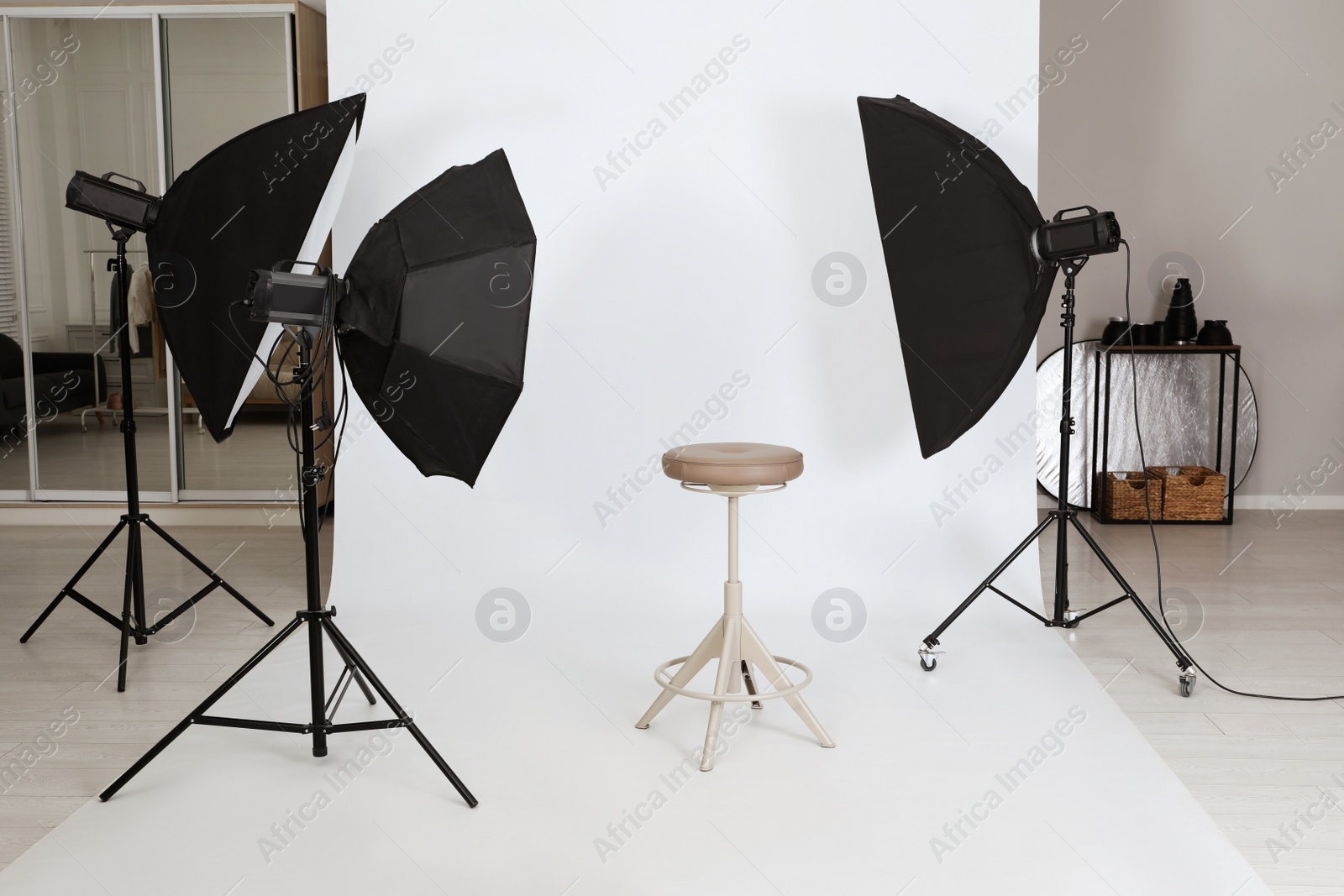 Photo of Empty stool surrounded by professional lighting equipment in photo studio