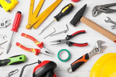 Flat lay composition with different construction tools on white wooden background