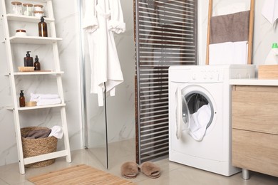 Stylish bathroom interior with modern washing machine