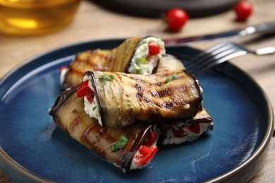 Delicious baked eggplant rolls with cheese, tomatoes and microgreens on plate, closeup