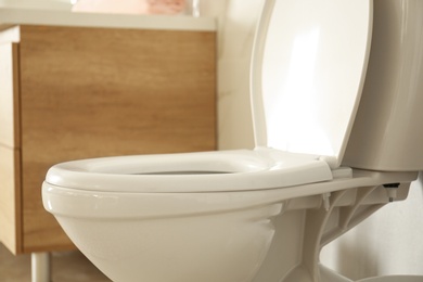 Photo of White toilet bowl in modern bathroom interior, closeup view