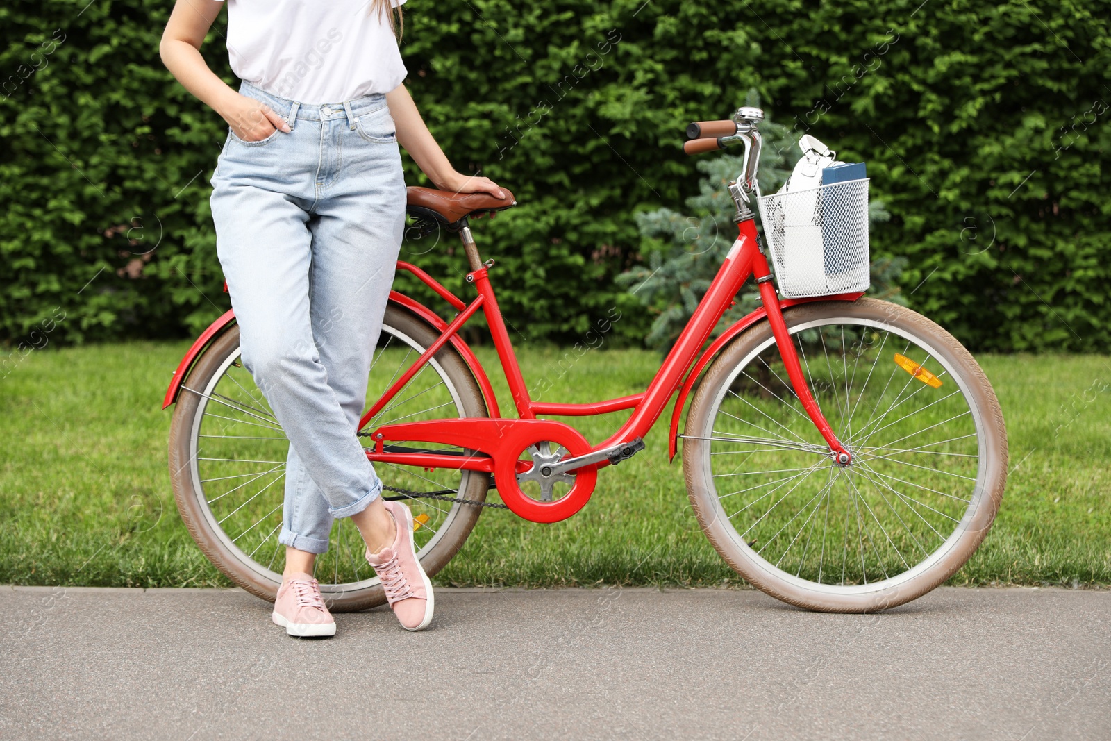 Photo of Young woman near modern color bicycle outside, closeup