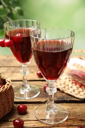 Photo of Delicious cherry wine with ripe juicy berries on wooden table