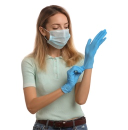 Young woman in protective face mask putting on medical gloves against white background