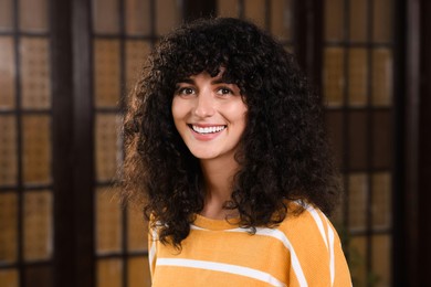 Photo of Portrait of happy young woman in stylish sweater indoors