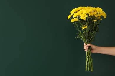 Photo of Woman holding beautiful bouquet near green chalkboard, space for text. Happy Teacher's Day