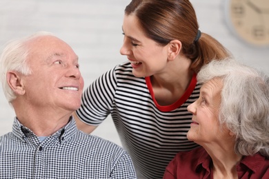 Photo of Elderly couple with female caregiver at home