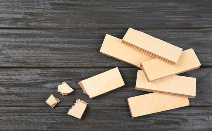 Photo of Delicious crispy wafers with chocolate filling on wooden table, flat lay