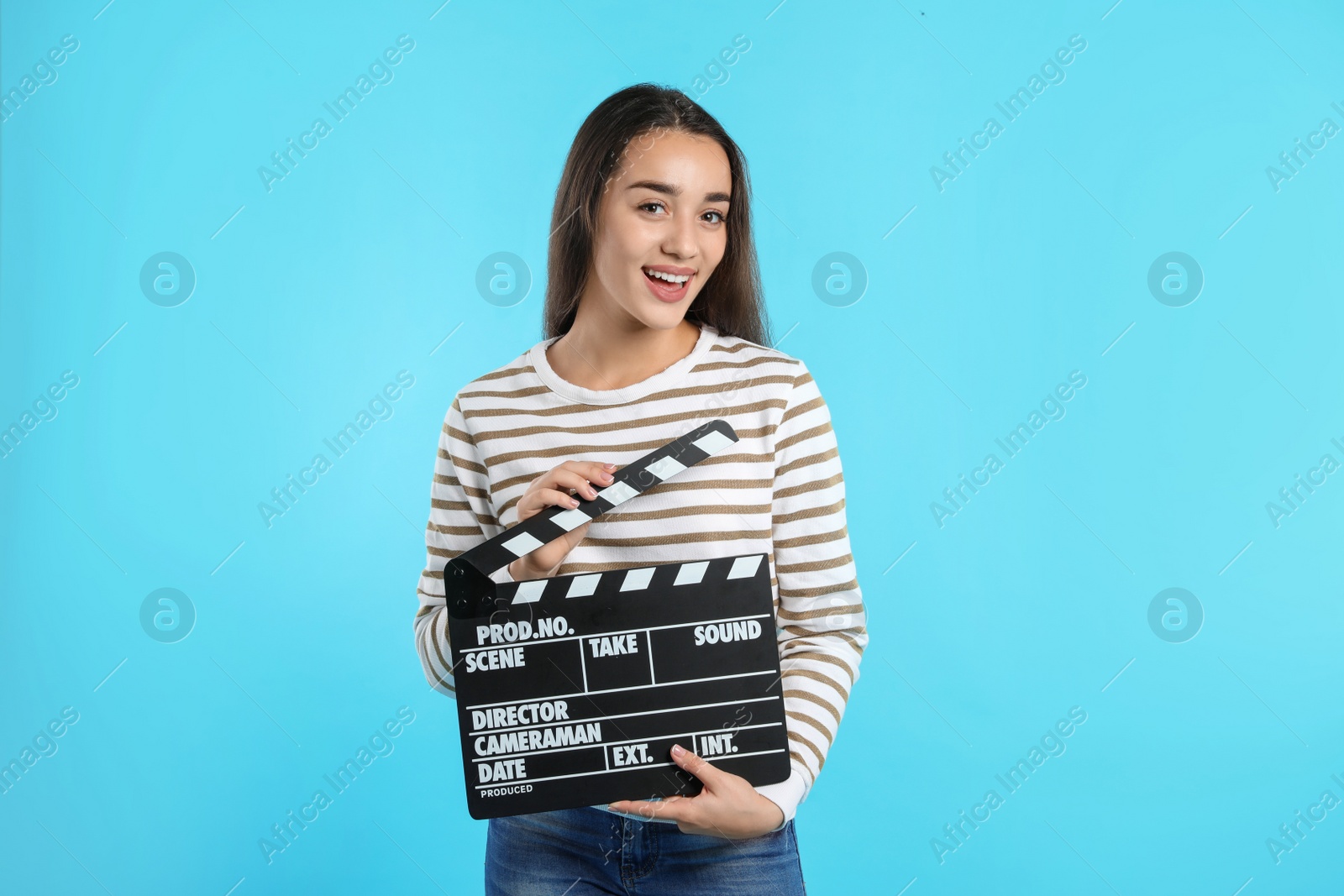 Photo of Woman with clapperboard on color background. Cinema show