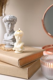 Beautiful David bust candles and books on table