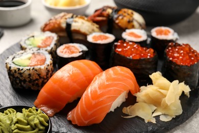 Set of delicious sushi rolls on light table, closeup