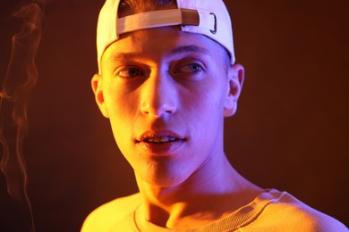 Young man on brown background in neon light