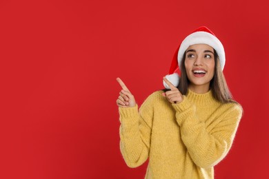 Photo of Happy woman in Santa hat on red background, space for text. Christmas countdown