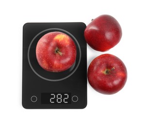 Ripe red apples and electronic scales on white background, top view