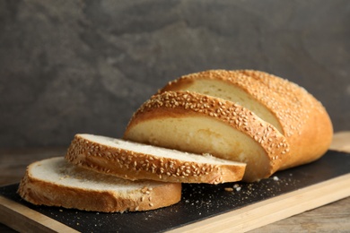 Board with tasty wheat bread on table