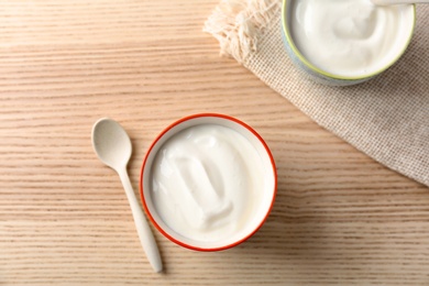 Cups with tasty yogurt on wooden  table, top view