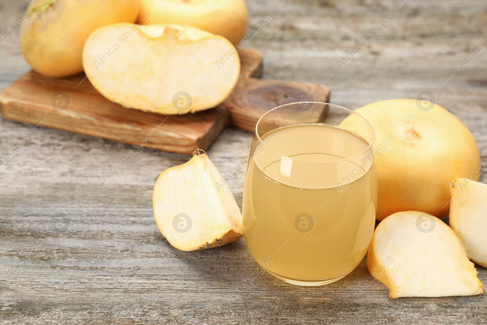 Photo of Glass of freshly made turnip juice on wooden table