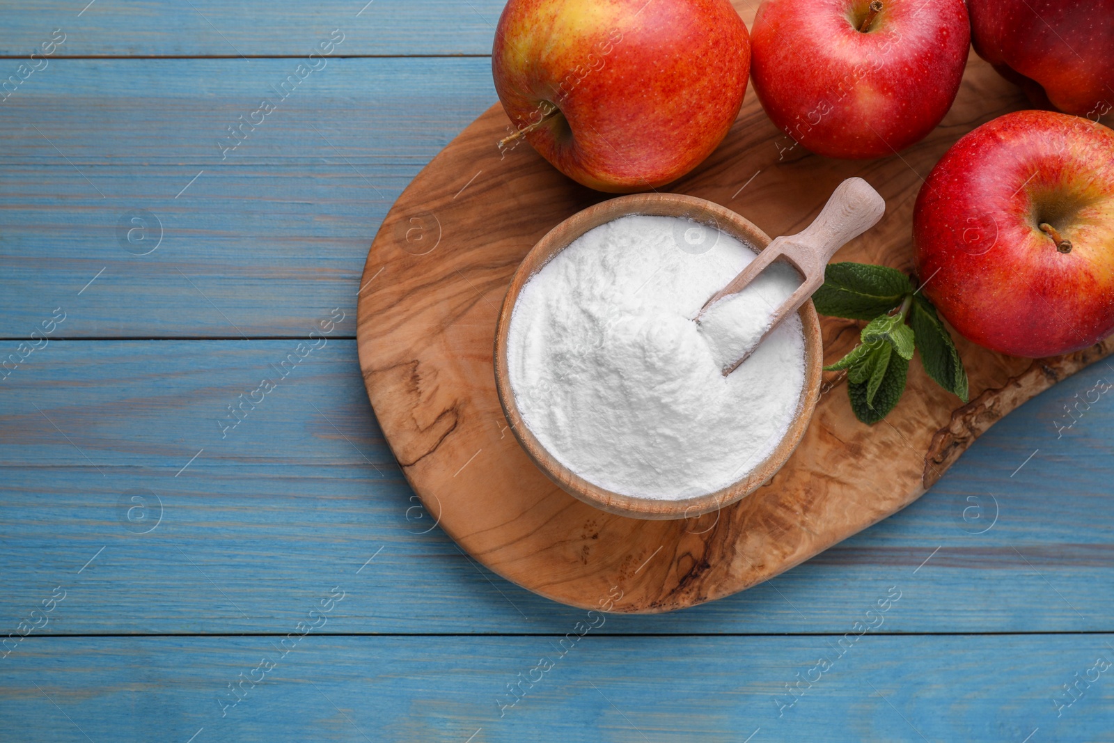 Photo of Sweet fructose powder, mint leaves and apples on light blue wooden table, top view. Space for text