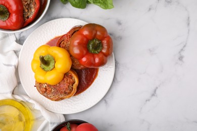 Photo of Delicious stuffed bell peppers served on white marble table, flat lay. Space for text