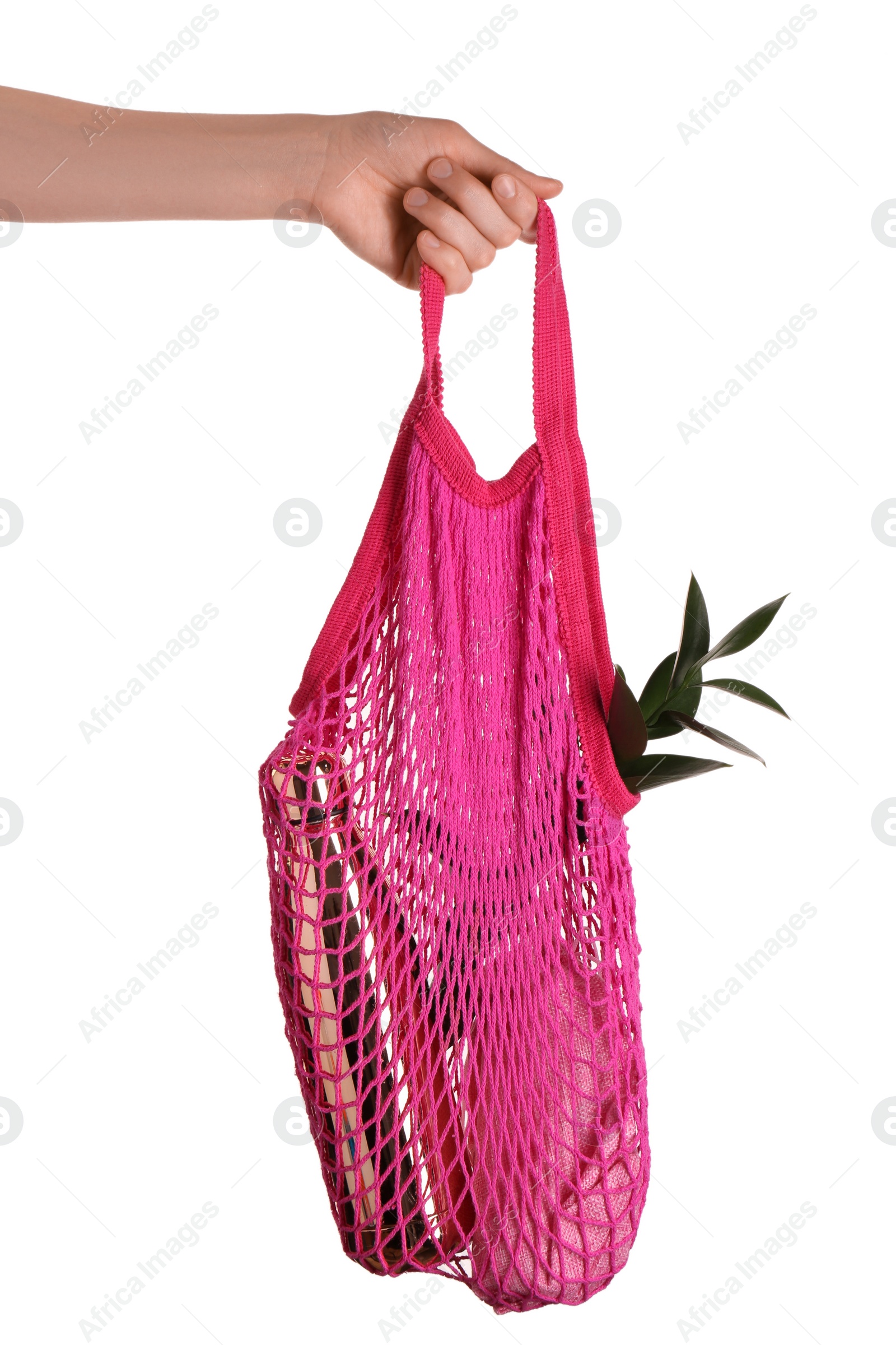 Photo of Woman holding net bag with different items on white background, closeup. Conscious consumption