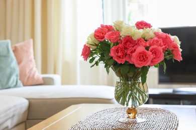 Photo of Vase with beautiful bouquet of roses on wooden table at home, space for text