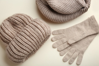 Photo of Stylish gloves, scarf and hat on beige background, flat lay