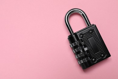 Photo of Steel combination padlock on pink background, top view. Space for text
