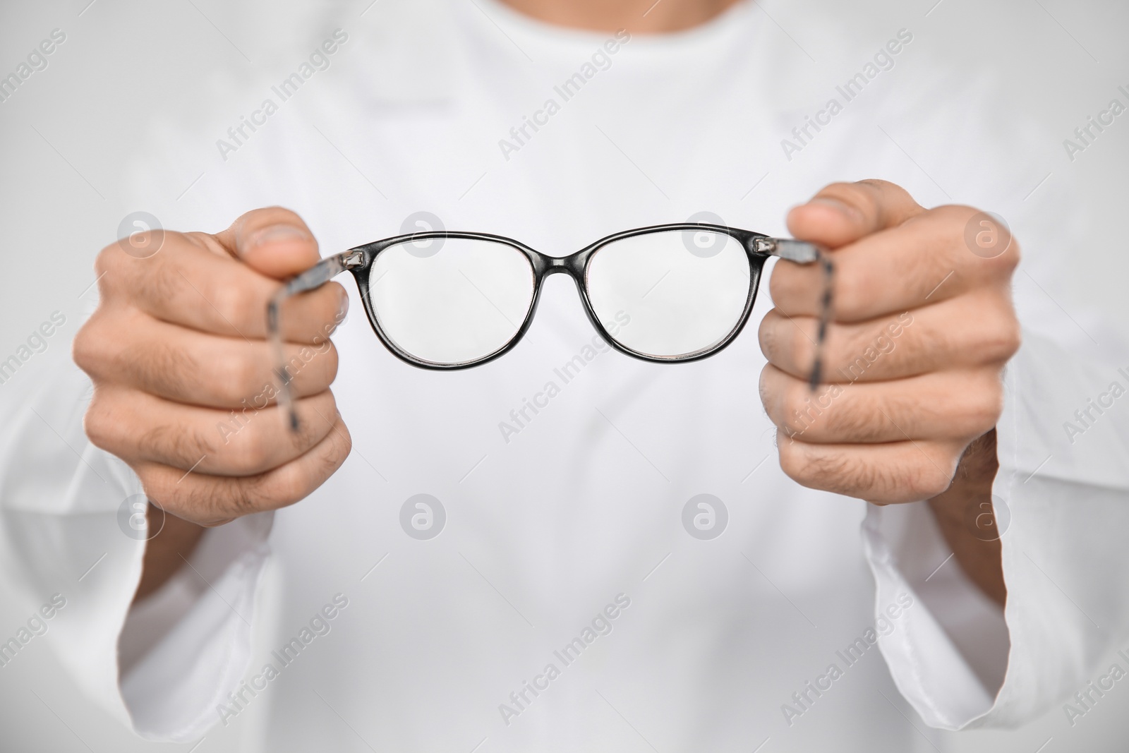 Photo of Male ophthalmologist with eyeglasses in clinic, closeup