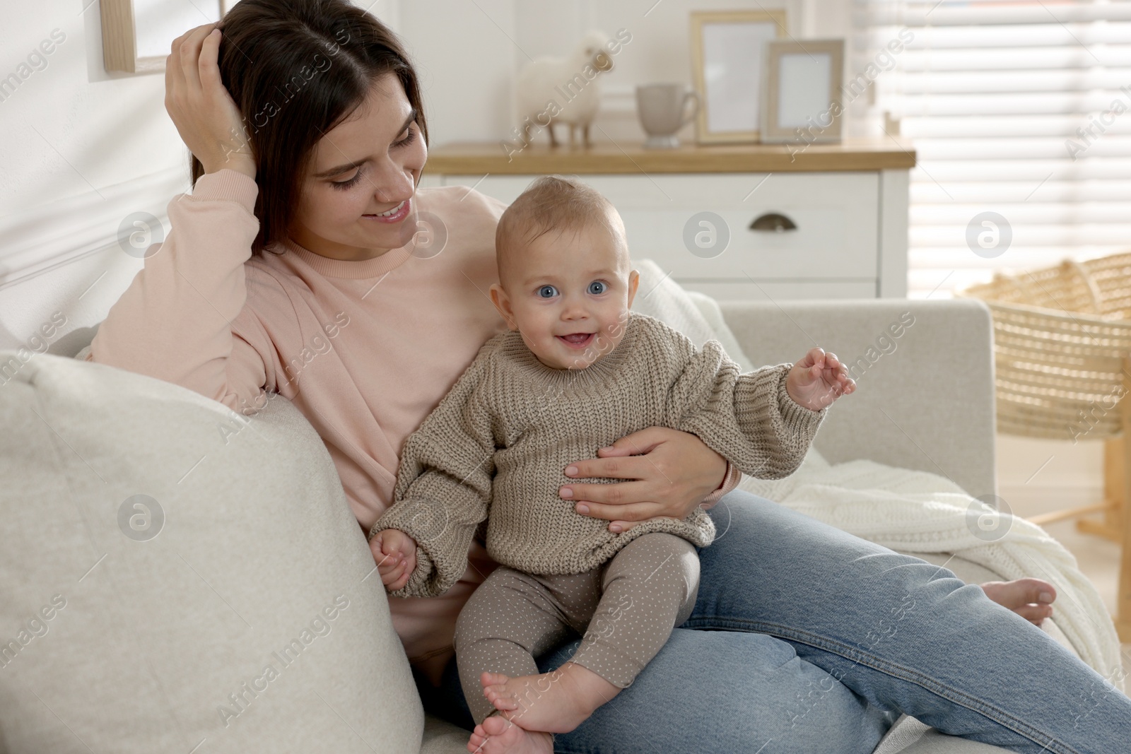 Photo of Happy young mother with her baby in living room