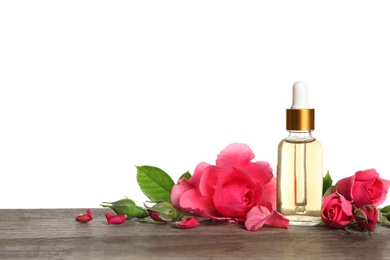 Photo of Bottle of rose essential oil and flowers on table, white background
