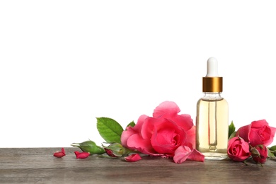 Bottle of rose essential oil and flowers on table, white background