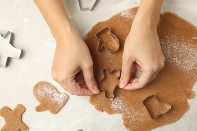 Woman making Christmas cookies at light table, top view