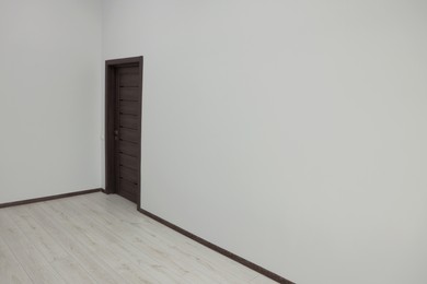 Empty renovated room with white walls and black door