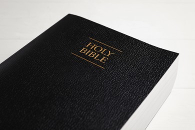 Photo of Closeup view of Holy Bible on white table. Religious book