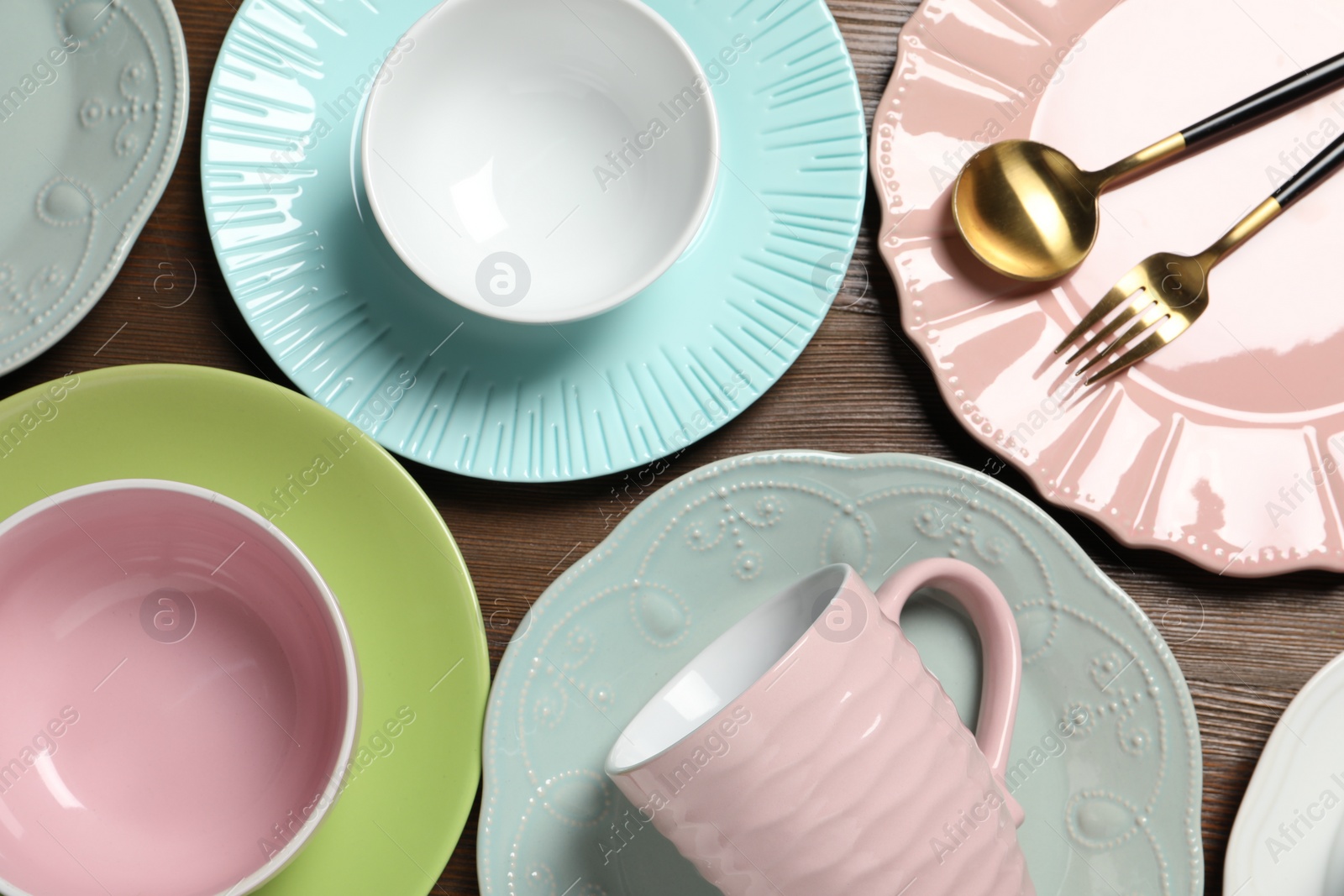 Photo of Beautiful ceramic dishware, cup and cutlery on wooden table, flat lay