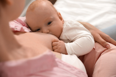 Photo of Young woman breast feeding her little baby, above view