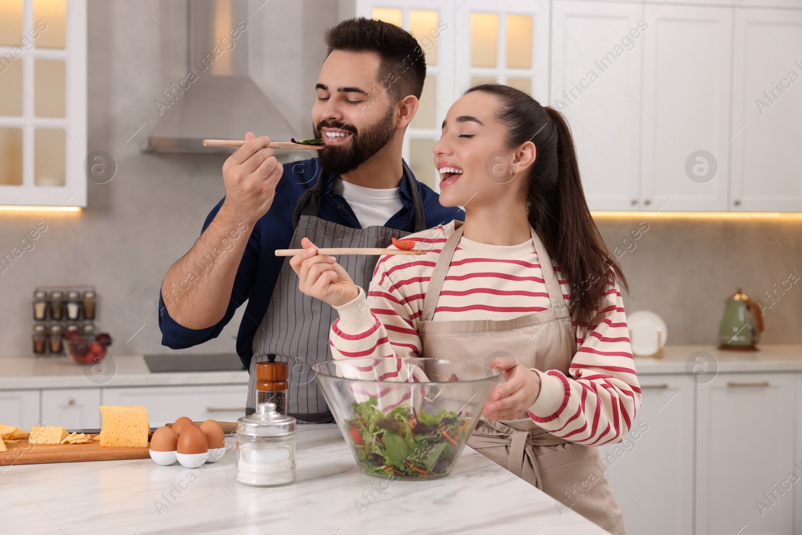 Photo of Happy lovely couple cooking together in kitchen