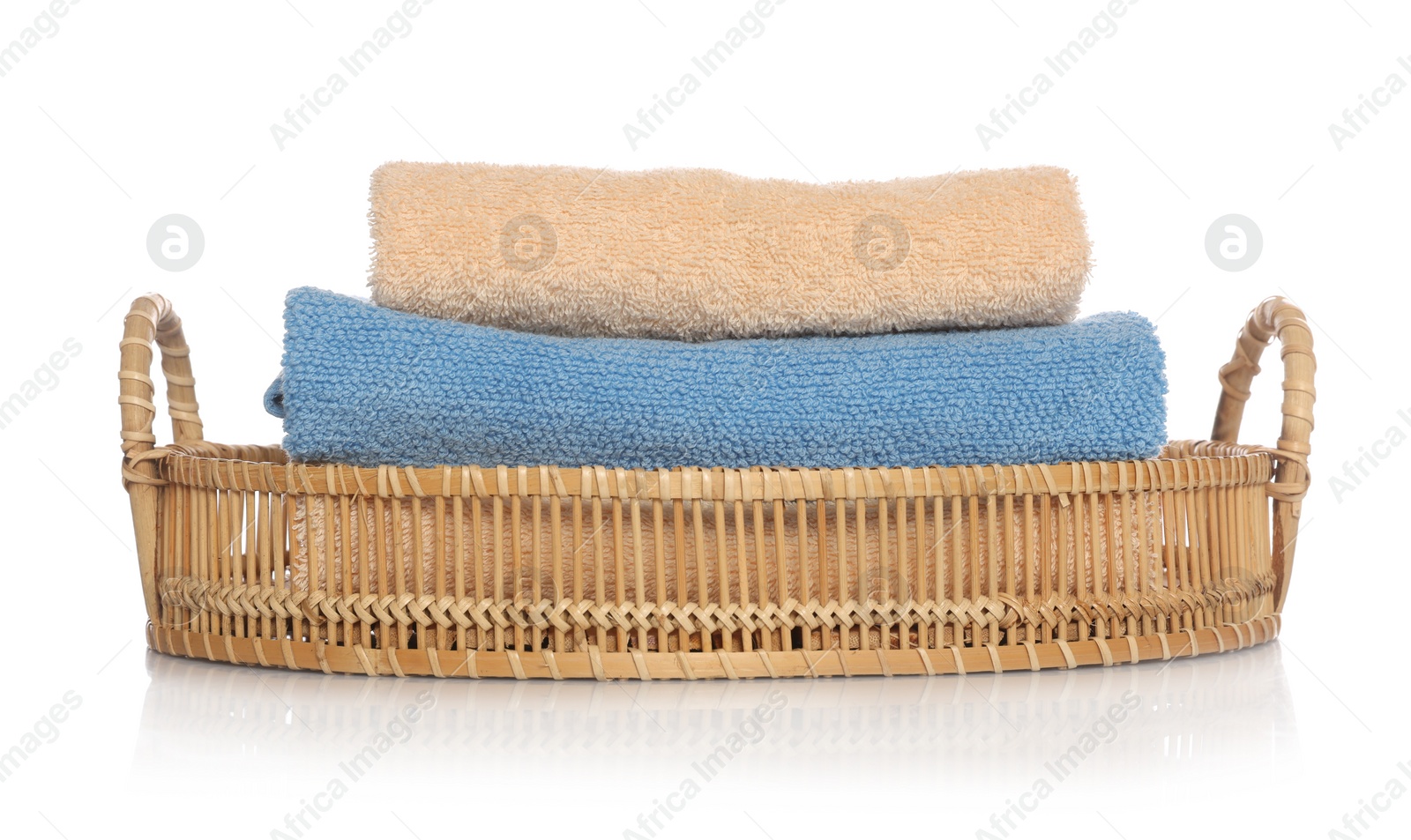 Photo of Soft towels in wicker basket on white background