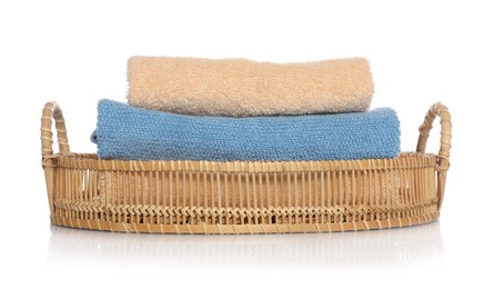 Soft towels in wicker basket on white background